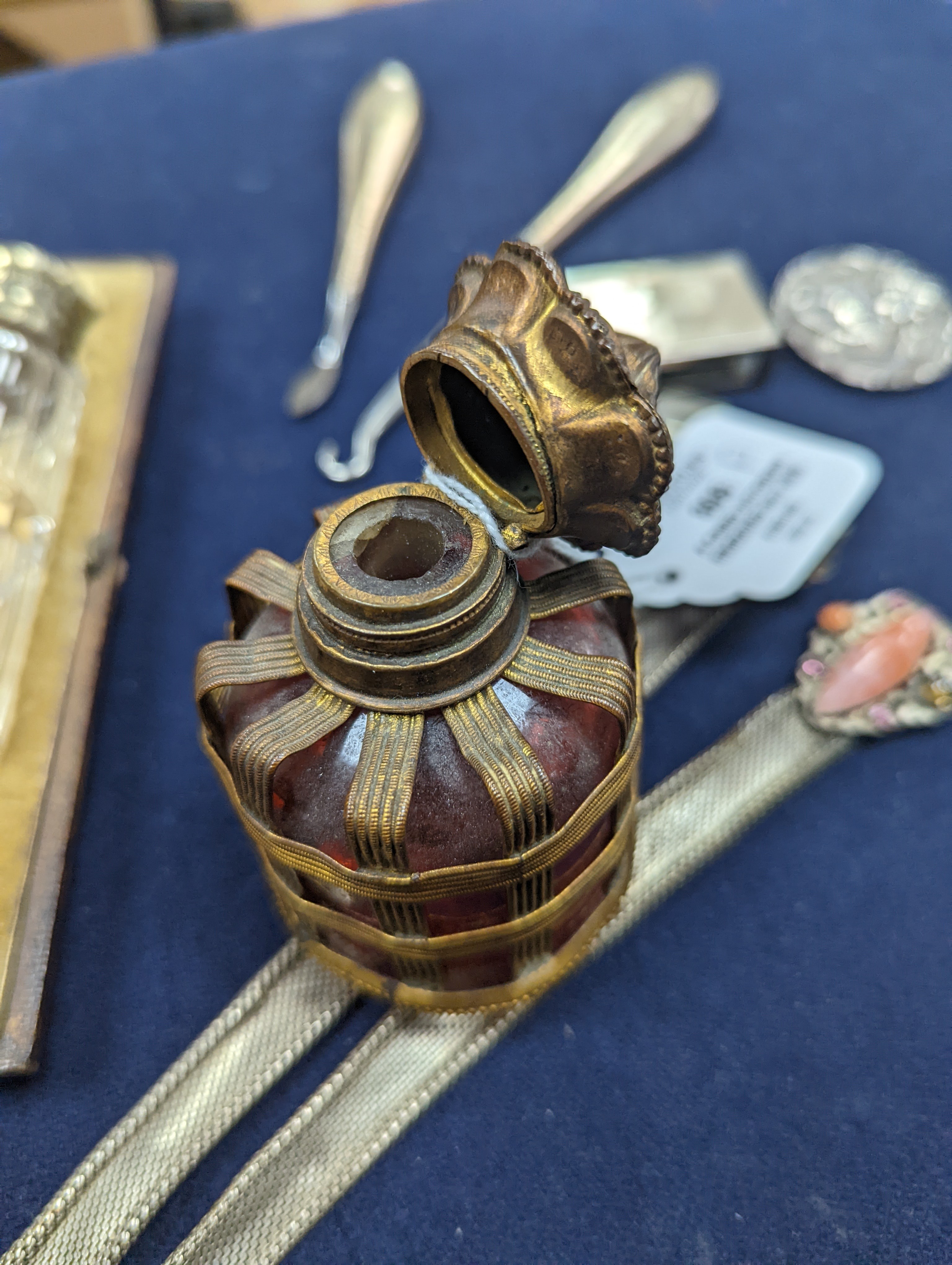 A cased Victorian engraved gilt white metal and coral set double ended scent bottle, 13.4cm, a silver cigar cutter, a belt, a silver buckle, gilt and cranberry perfume bottle, etc.